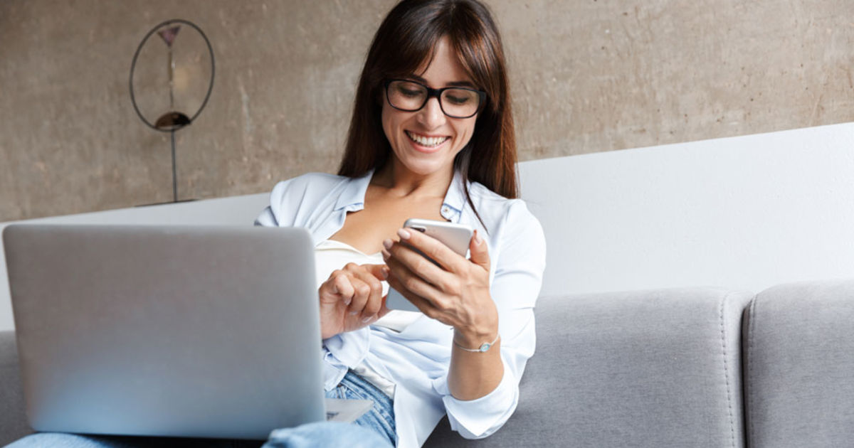 smiling woman with phone and computer